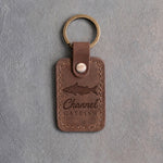 Sicilian brown leather keychain debossed with a channel catfish above Channel and CATFISH, on gray concrete