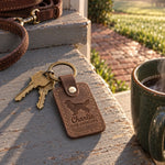 Sicilian brown Charlie the Cavalier keychain held in a warm everyday setting