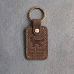 Sicilian brown leather keychain debossed with a Cavalier King Charles Spaniel silhouette above Best friend and THE CAVALIER, on gray concrete