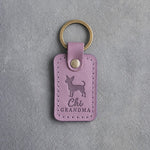 Lilac leather keychain debossed with a chihuahua silhouette and the words Chi GRANDMA, on gray concrete