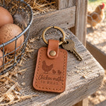 Caramel Chicken Math keychain on a weathered pine nesting box ledge beside brown eggs in a wire basket, a hen soft in the run behind