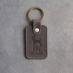Country gray leather keychain with a debossed chihuahua and Chi DAD lettering on gray concrete