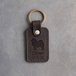 Dark espresso leather keychain debossed with a Chow Chow silhouette and the words Chow DAD, on gray concrete
