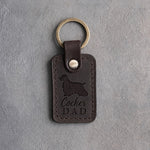 Dark espresso leather keychain debossed with a cocker spaniel silhouette and Cocker DAD, on gray concrete