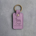 Lilac leather keychain debossed with a Pembroke corgi silhouette and the words Corgi GRANDMA, on gray concrete