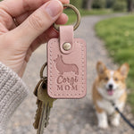 Pink Corgi Mom keychain held up on a park path as a smiling corgi on a leash looks toward the camera