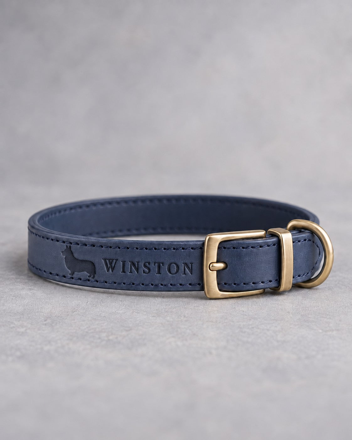Blueberry blue leather dog collar with a corgi silhouette and the name WINSTON debossed, brass pin buckle
