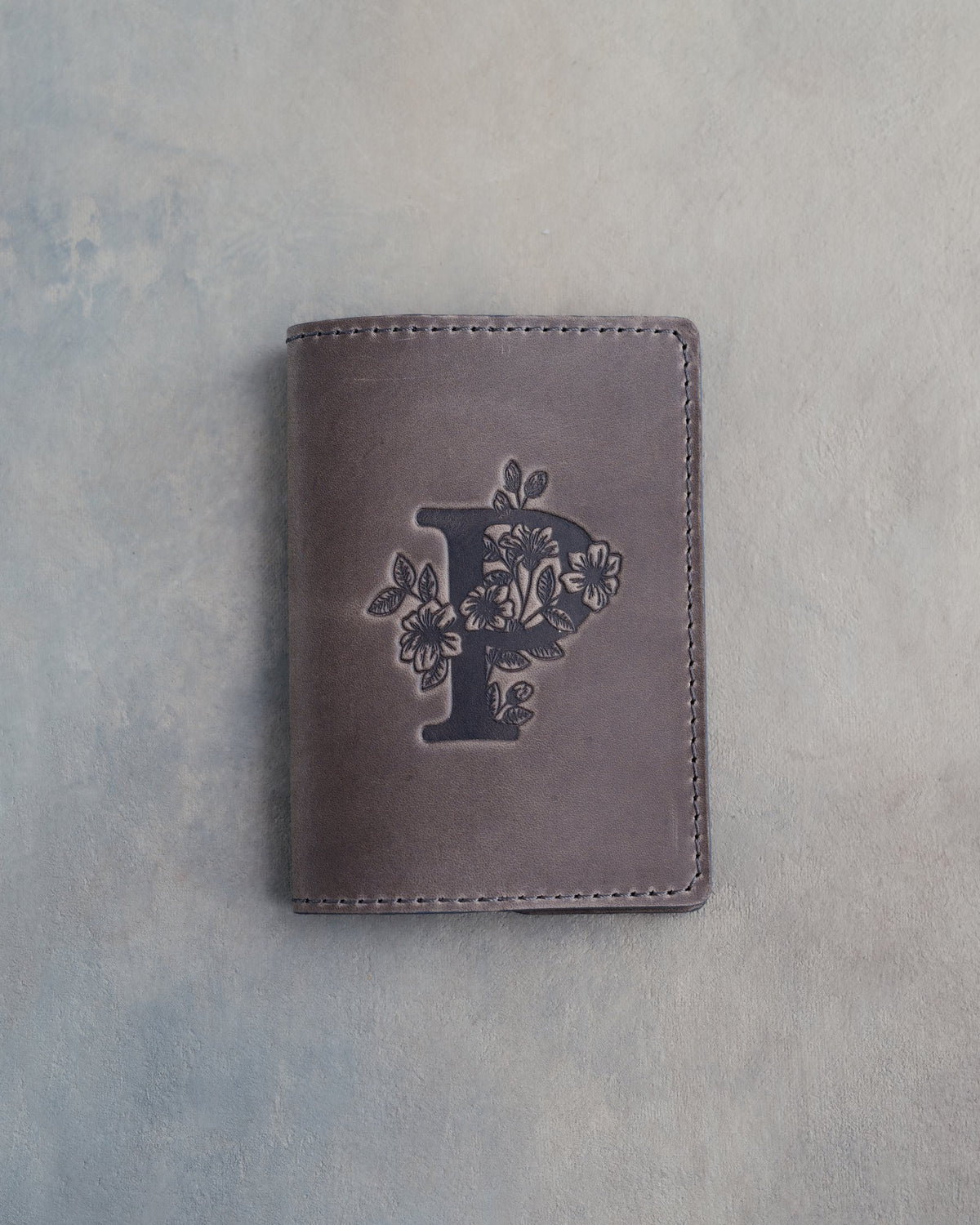 Country Gray leather passport cover with a large floral initial P pressed into the front
