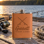 Caramel Garrett TIGHT LINES hip flask in full-grain leather on sun-bleached dock boards beside a spinning rod in low evening sun