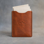 Arizona leather business card holder debossed with a sample business logo, on a grey plaster backdrop