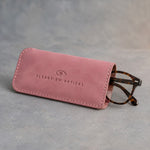 Parisian Blossom slip-in leather glasses case with stitched edge, debossed with a sample business logo, on grey plaster