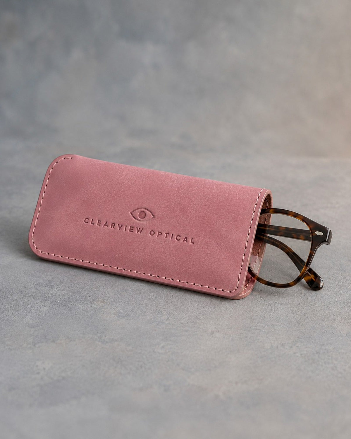 Parisian Blossom slip-in leather glasses case with stitched edge, debossed with a sample business logo, on grey plaster