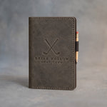 Country Gray leather golf scorecard holder debossed with a sample business logo, on a grey plaster backdrop