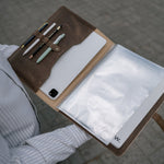 Open leather padfolio with a tablet in the left pocket, clear sheet-protector pages and a letter-size notebook