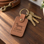Caramel Oscar the Doxie keychain with brass house keys on a walnut entry table, a tan leash behind