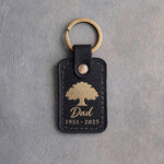 Black leather keychain with a gold foil oak tree above Dad and 1951 · 2025
