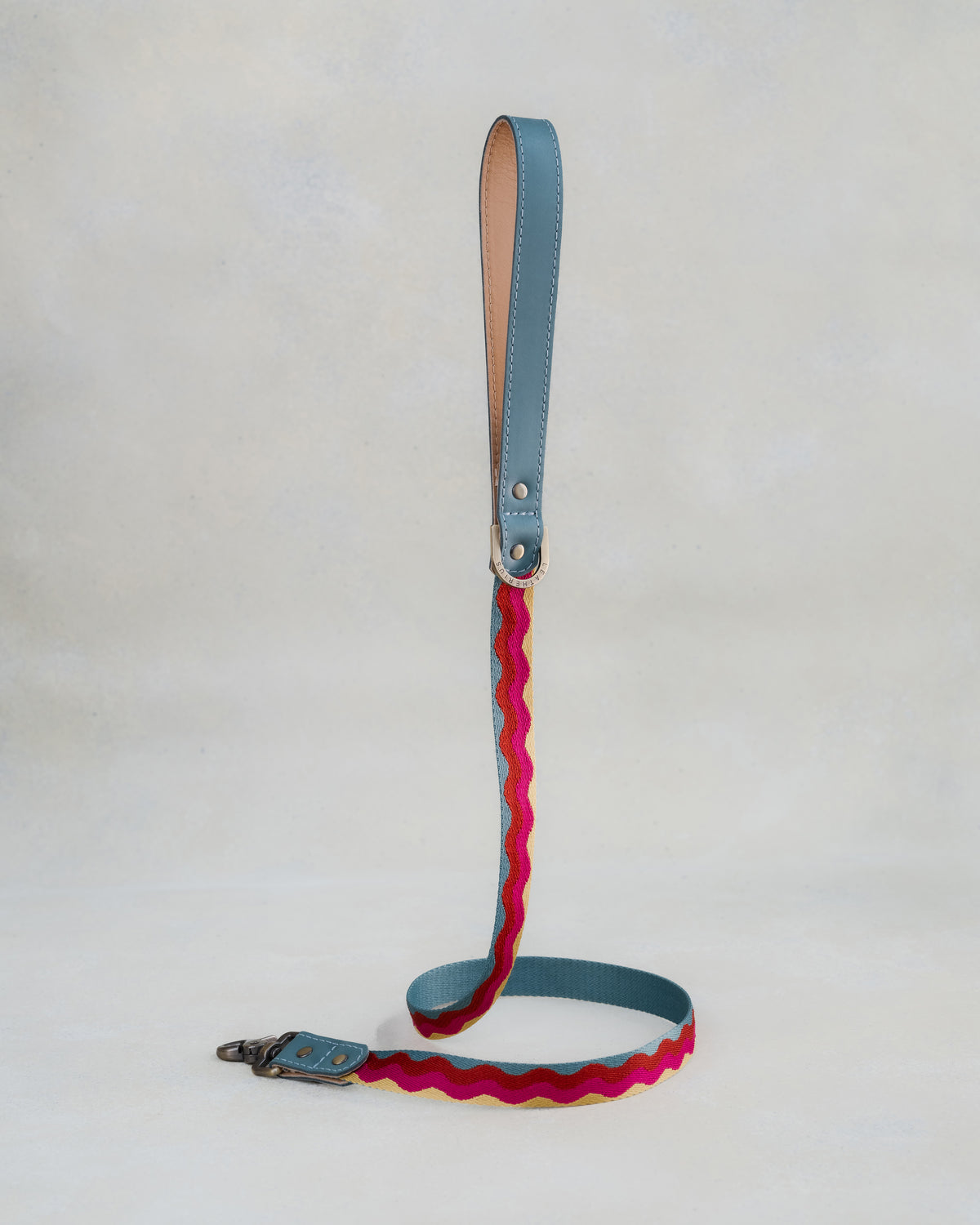 Matching Summer Waves leash with leather trim and a brass clip