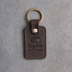 Dark espresso leather keychain debossed with a dog bowl and the words Dog hair IN MY COFFEE, on gray concrete