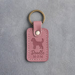 Parisian Blossom pink leather keychain with a debossed goldendoodle and the words Doodle MOM on gray concrete