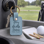 Drives the Cart keychain in turquoise leather hanging from a golf cart key in bright resort sunshine