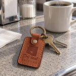 Dry Heat Arizona keychain in tan leather on car keys resting on a sunbaked dashboard