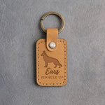 Indian Summer tan leather keychain debossed with a German shepherd silhouette with upright ears and the words Ears FINALLY UP, on gray concrete