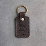 Dark espresso leather keychain debossed with an English Setter silhouette and the words Setter DAD, on gray concrete