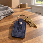 Navy The Millers SINCE 1994 keychain on a new set of house keys by a front door