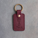 Sangria red leather keychain debossed with a piston and rod above Fires on and ALL CYLINDERS