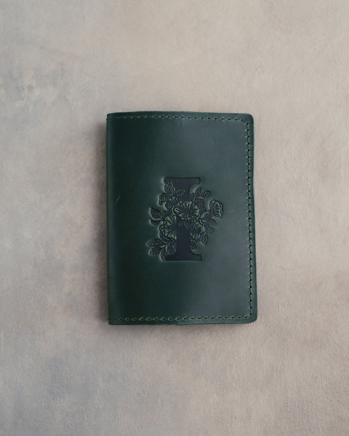 Forest Green leather passport cover with a large floral initial I pressed into the front