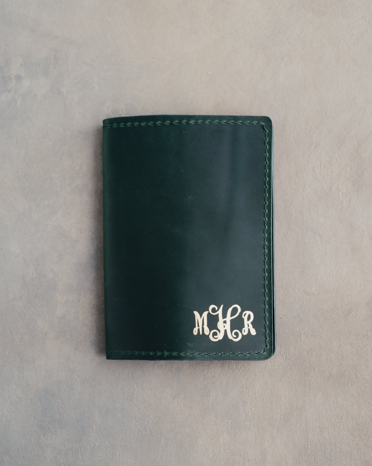 Forest Green leather passport cover with the vine monogram MHR in the bottom corner