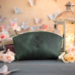 Initial leather makeup bag in forest green with a floral monogram deboss, roses and a glowing lantern behind