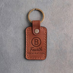 Arizona leather keychain debossed with a Circle B ranch brand above Fourth and GENERATION, on gray plaster