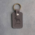 Country gray leather keychain with a debossed French bulldog, the name Louie and THE FRENCHIE, on gray concrete