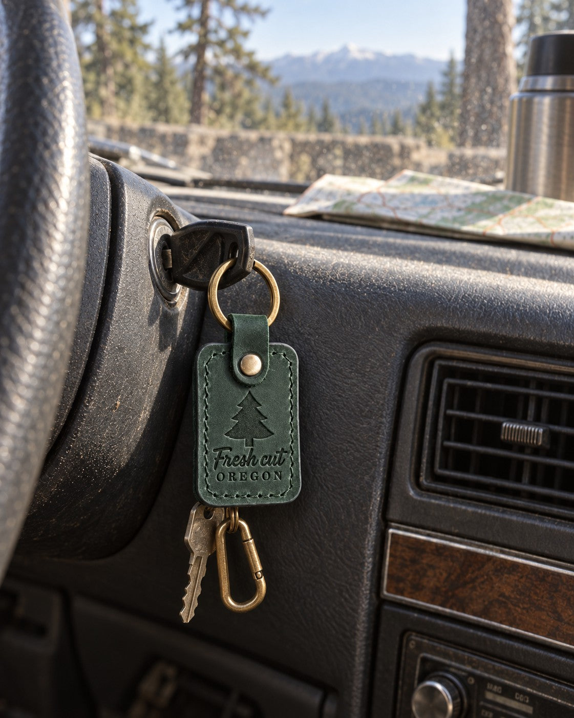 Green Fresh Cut Oregon keychain on truck keys resting on a freshly cut fir tied to a roof rack