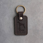 Dark espresso leather keychain debossed with a German Shorthaired Pointer silhouette, the name Remi and THE GSP, on gray concrete
