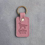 Pink Parisian Blossom leather keychain with a debossed golden retriever and the words Golden MOM on gray concrete