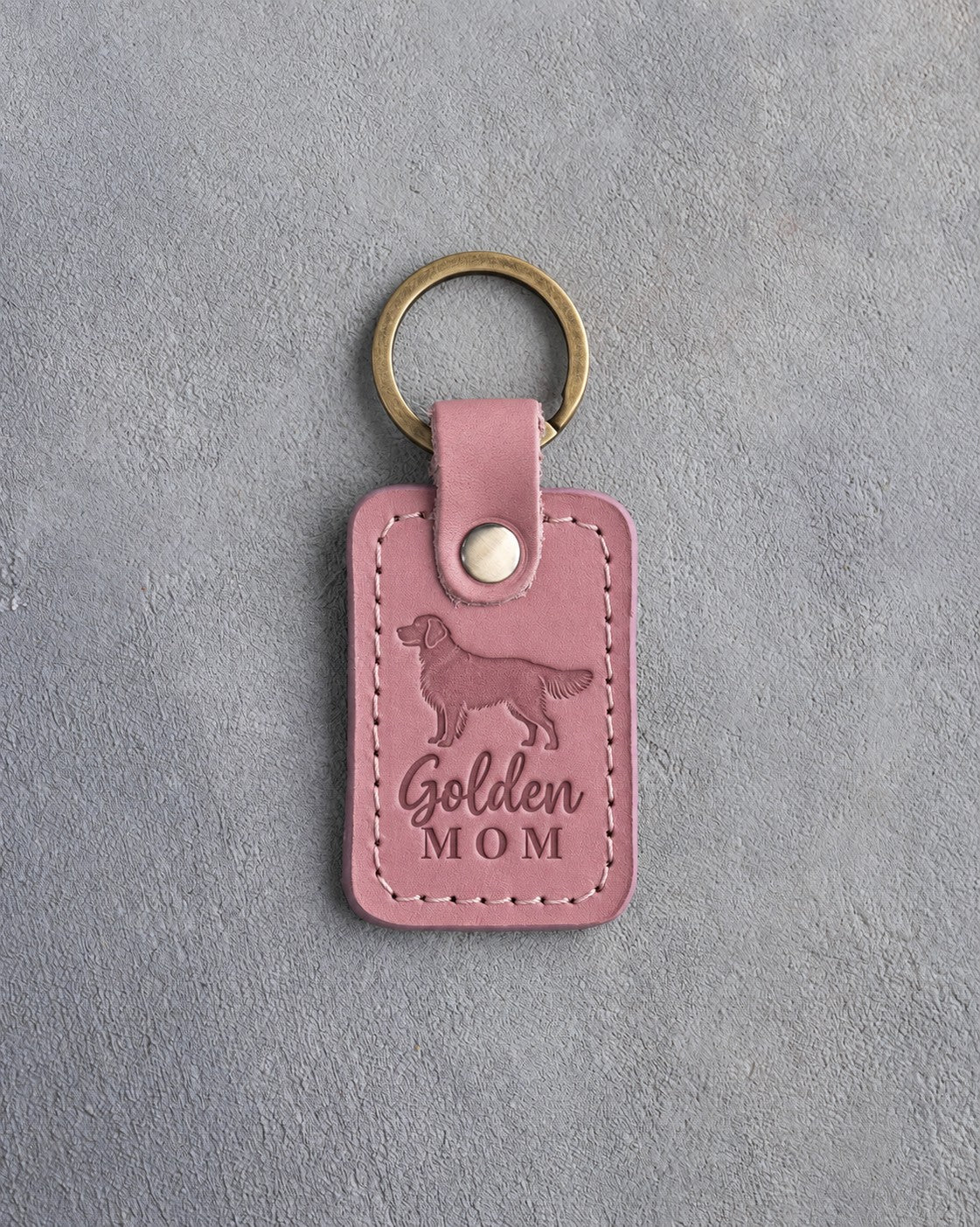 Pink Parisian Blossom leather keychain with a debossed golden retriever and the words Golden MOM on gray concrete