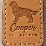 Close-up of Cooper in brush script and THE GOLDEN pressed into tan full-grain leather below a feathered golden retriever