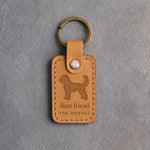 Indian Summer tan leather keychain debossed with a curly goldendoodle above Best friend and THE DOODLE, on gray concrete