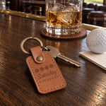 Four Saturday Foursome keychains in different leathers laid in a row on a golf cart seat