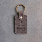 Country gray leather keychain debossed with a golf pin flag above the words Meet me at the and HOME COURSE, on gray concrete