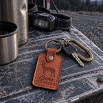 Gone Hunting keychain in tan leather on truck keys beside a handwritten note and a coffee mug on a kitchen table