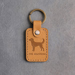 Indian Summer tan leather keychain debossed with an alert dog above THE GRANDDOG, on gray concrete