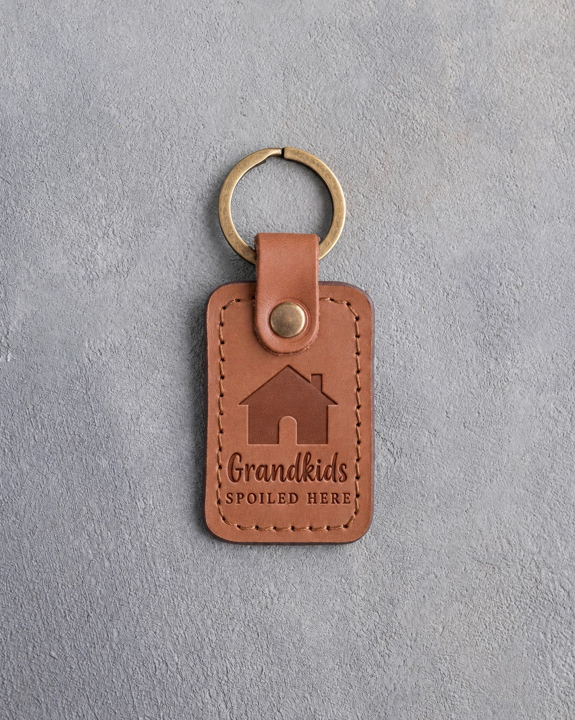 Caramel leather keychain debossed with a gabled house above Grandkids and SPOILED HERE