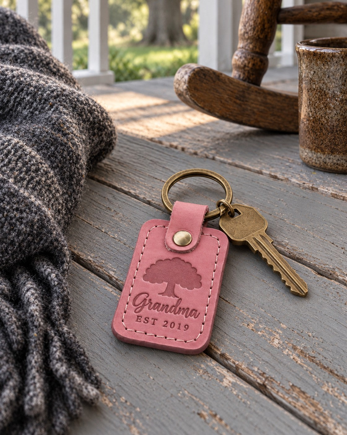 Rose pink Grandma EST 2019 keychain on a key ring beside a basket of yarn