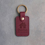 Sangria red leather keychain debossed with a gabled house above Grandma's and HOUSE RULES