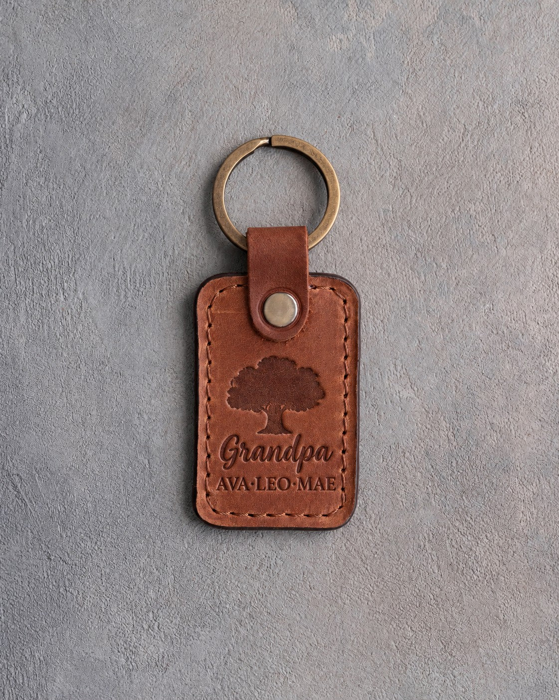 Arizona tan leather keychain debossed with a solid oak tree above Grandpa and AVA·LEO·MAE