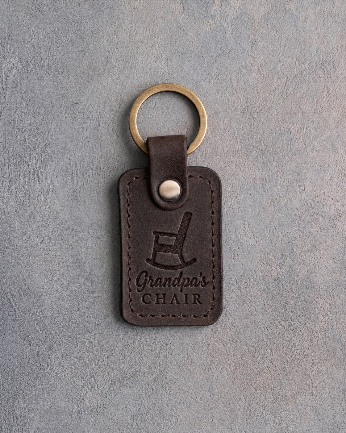 Dark espresso leather keychain debossed with a rocking chair above Grandpa's and CHAIR