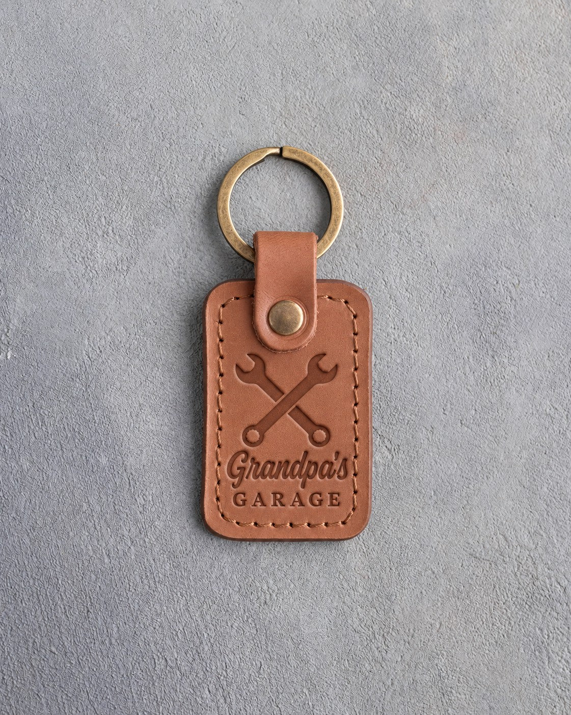 Caramel leather keychain debossed with crossed wrenches above Grandpa's and GARAGE